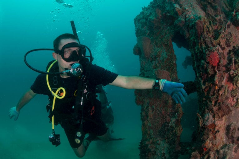 Navy Diver exploring underwater wreck while wearing G-Shock DW6900