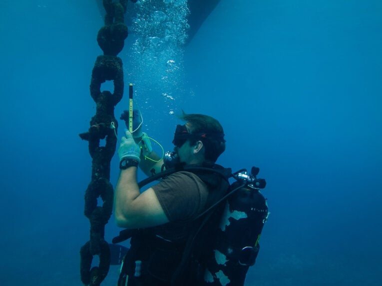Navy Seabea diver inspecting buoy underwater while wearing G-Shock DW6900